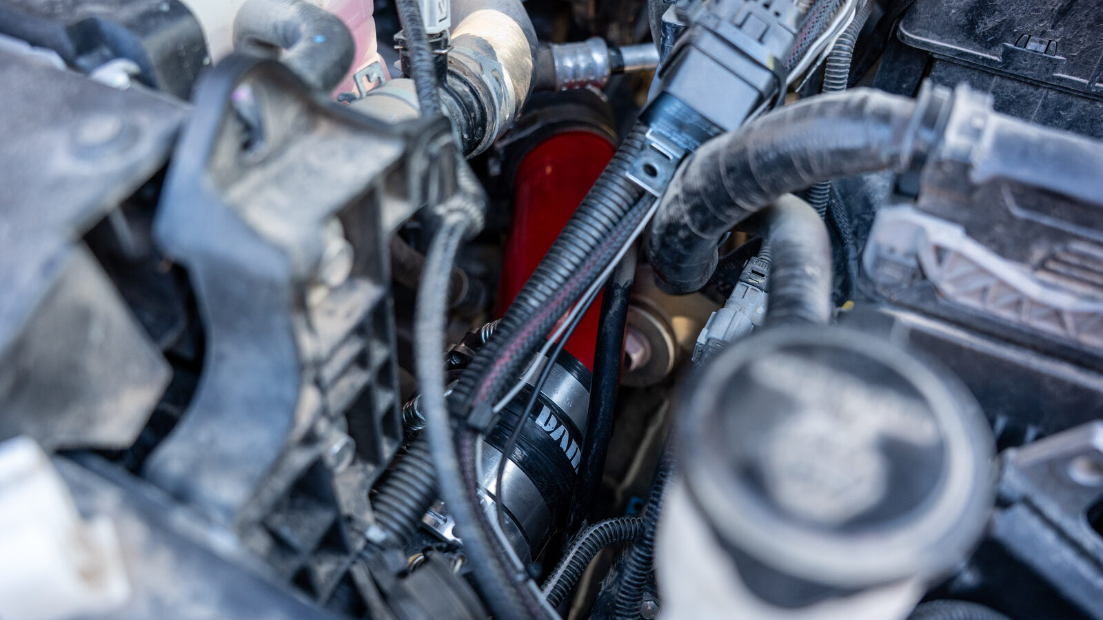 Banks 26012 boost tube installed in the 4G Tacoma engine bay, red silicone coupler and Banks-branded sleeve clamped to the stainless charge tube