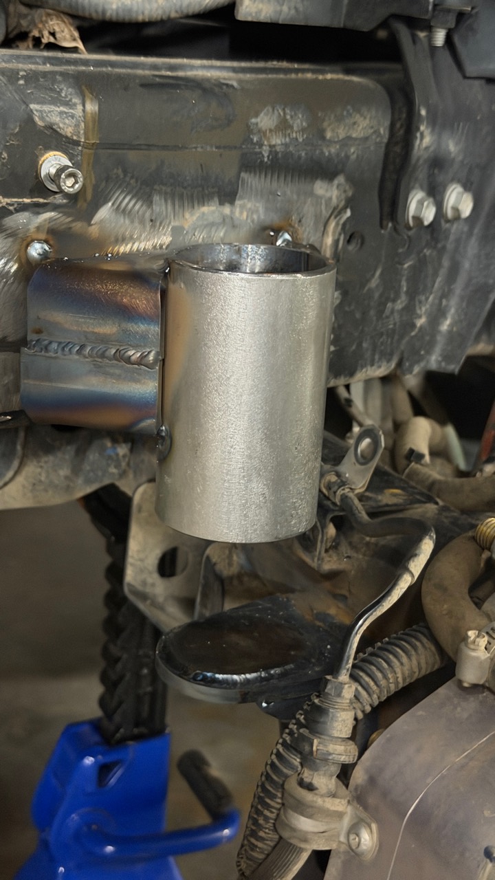 Bare rear bump-stop holder welded to a fabricated frame bracket above a black axle-side strike surface