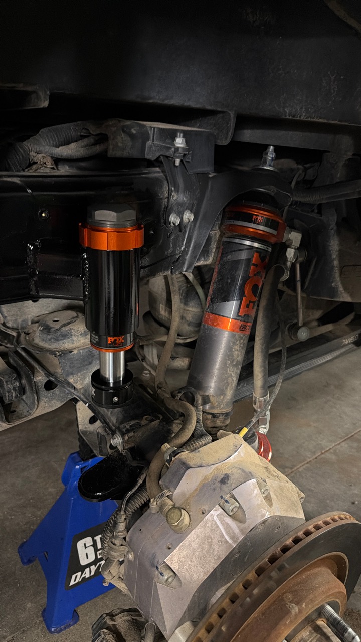Installed rear FOX hydraulic bump stop beside the FOX Live Valve shock, with the custom strike surface and 74Weld portal hub below