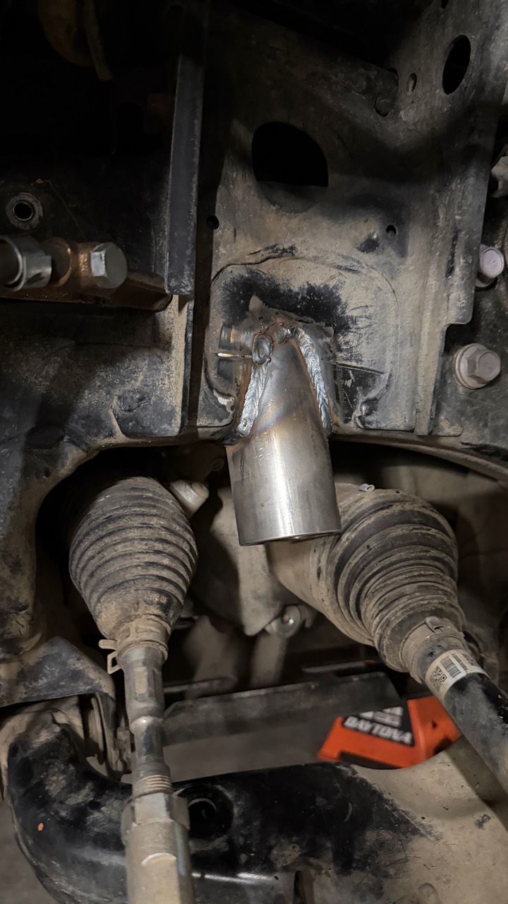 Fabricated front bump-stop holder welded to the chassis beside the steering and CV boots, before coating