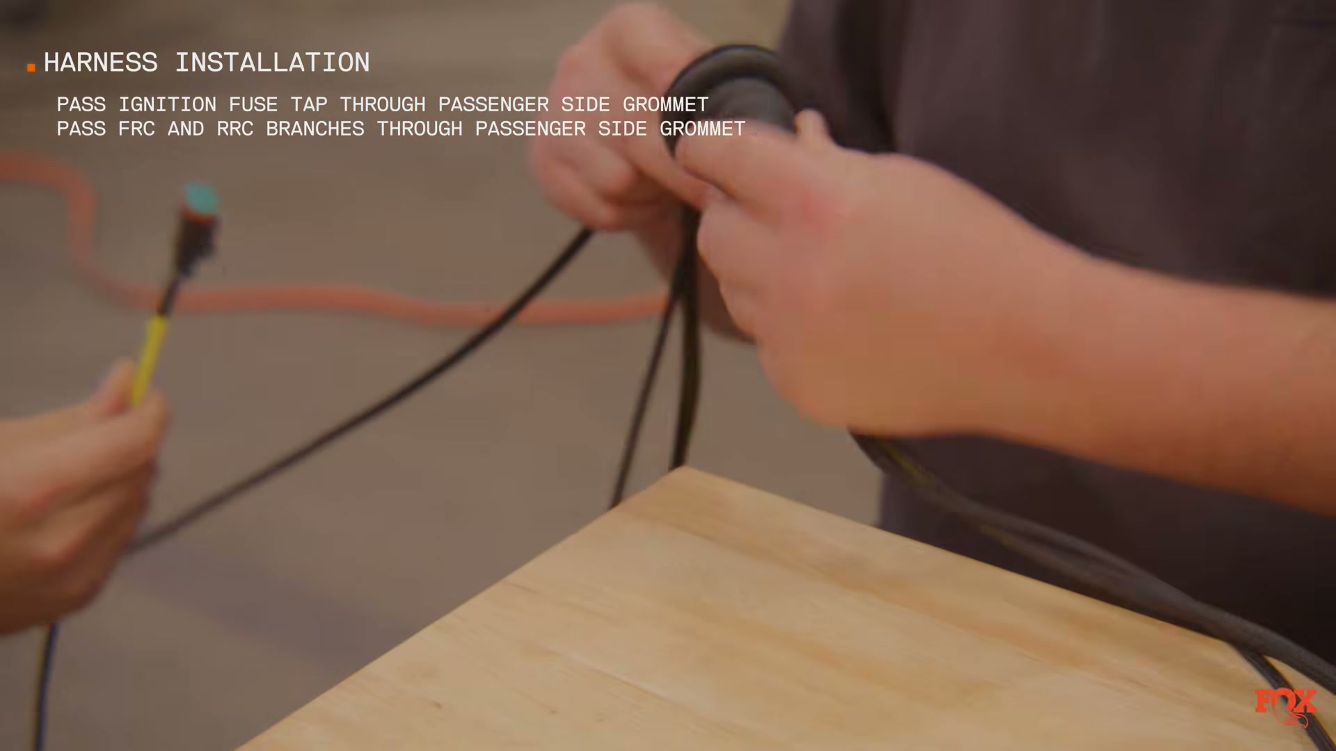 Fox Live Valve wiring loom being routed through cab floor to frame rail — source: Fox Racing