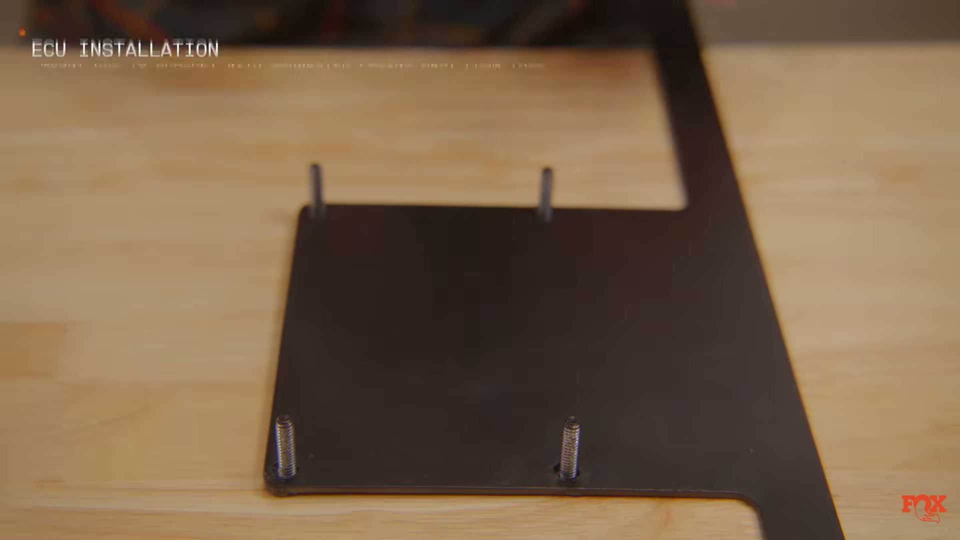 Fox Live Valve ECU mounting bracket — installs under driver's side carpet — source: Fox Racing