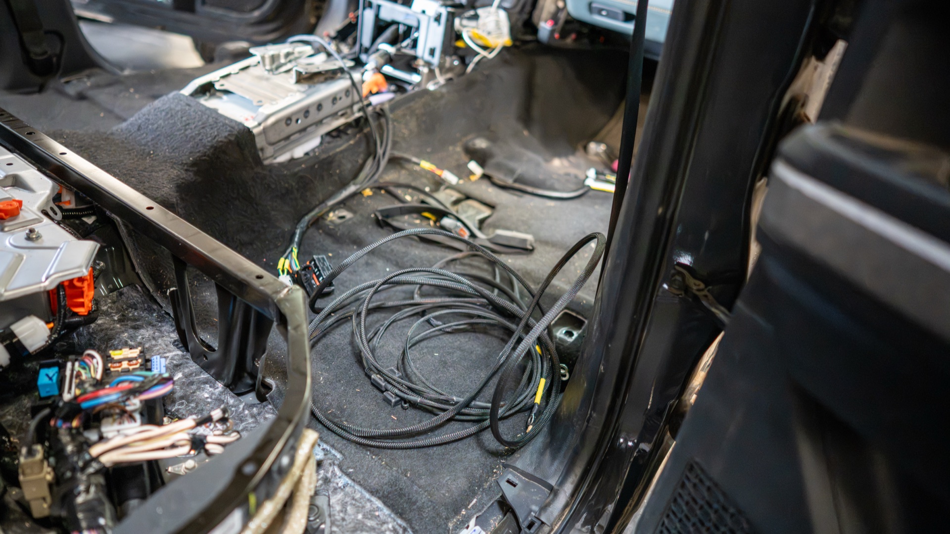 Fox wiring loom coiled on the bare cab floor of my Tacoma with branches staged for the floor penetrations — photo: SDHQ Off Road