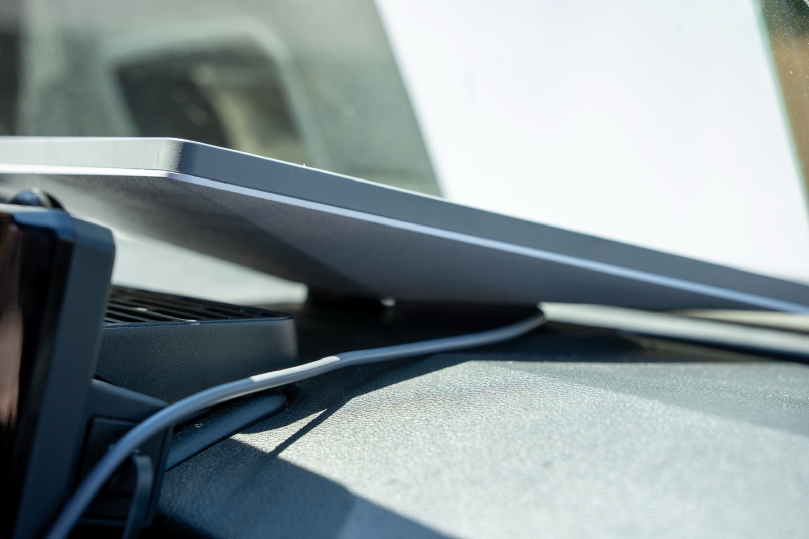 Close-up of the Starlink Mini seated in the Broken Rover dashboard mount with the USB-C power cable routed along the Tacoma dash