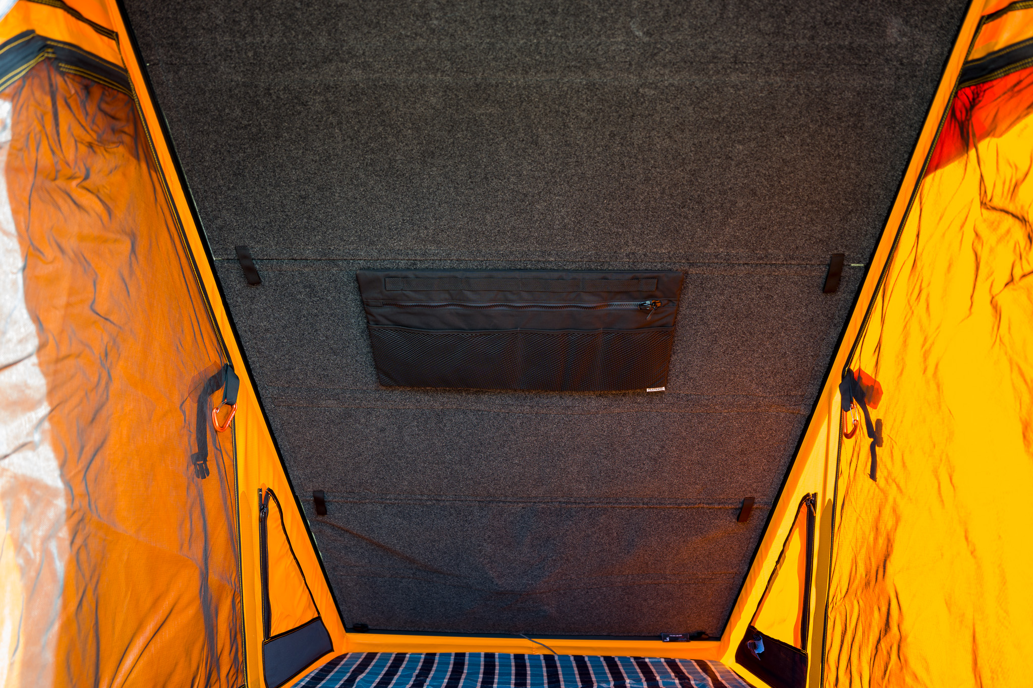 Inside the GFC V2 Pro camper — orange tent walls, ceiling storage pocket, and Pro Headliner covering the Starlink Mini mounted above