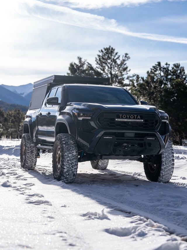 Tacoma with GFC camper parked in snow with mountains behind